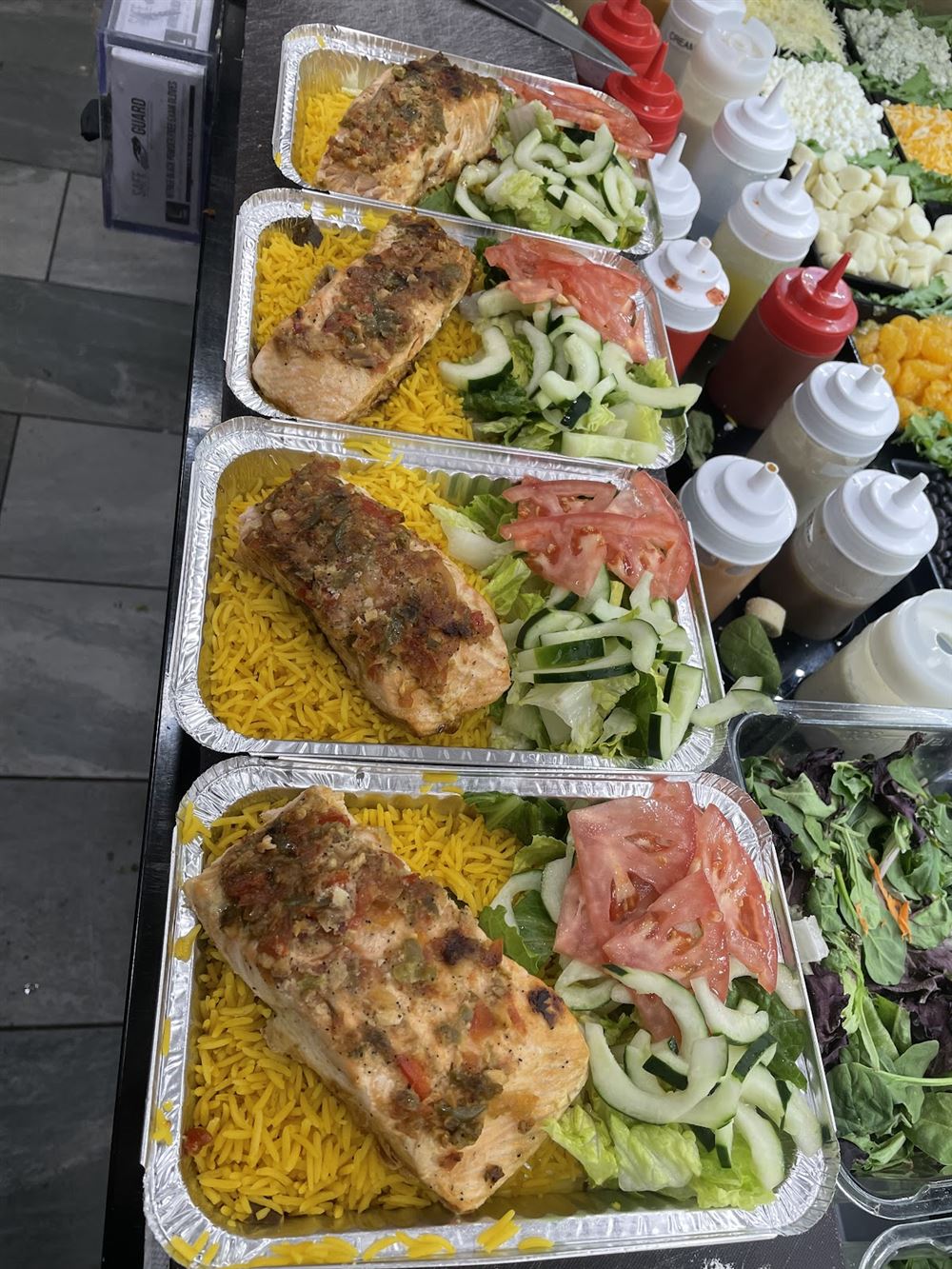 Fresh salmon platters with yellow rice and salad beside the salad bar at Krave